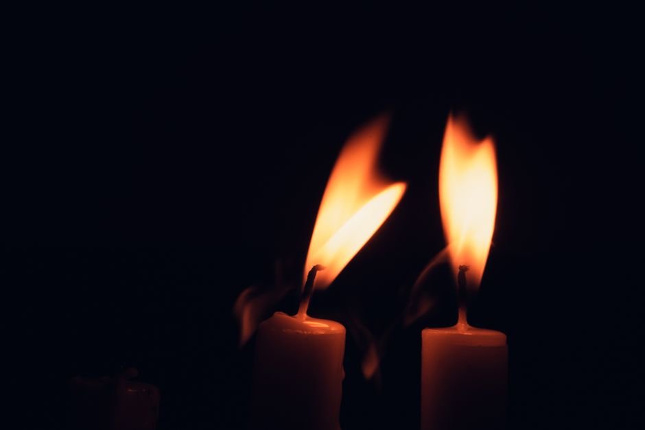 Deux flammes de bougie se rejoignant dans le noir