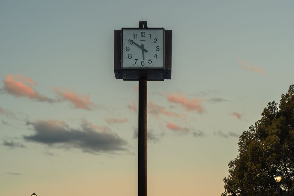 Horloge isolée sur un poteau dans un ciel crépusculaire