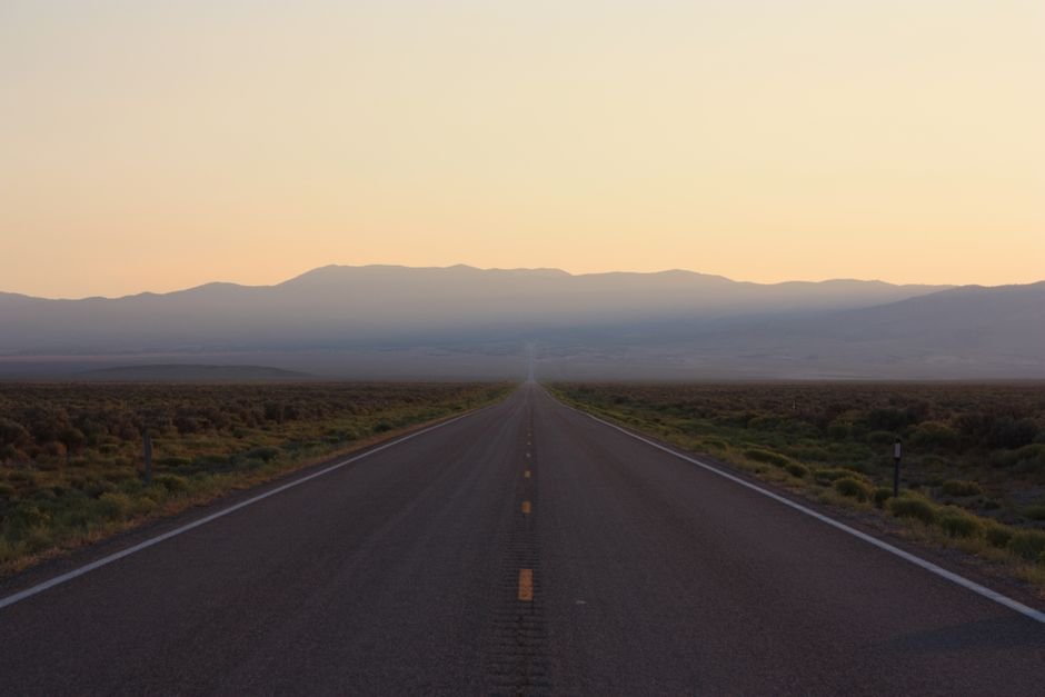 Longue route déserte s'étirant vers l'horizon au crépuscule