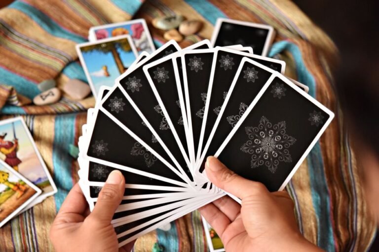 Mains tenant un jeu de tarot en éventail