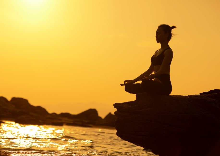 Personne en posture de yoga au bord de la mer